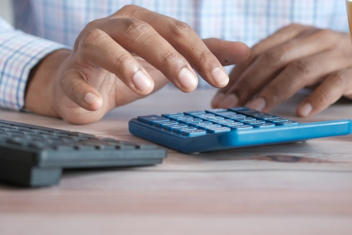 An accountant working through the numbers at a desk calculator
